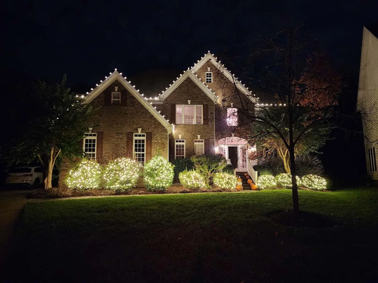 Warm white roofline and landscape Christmas lighting on a Denver-area home