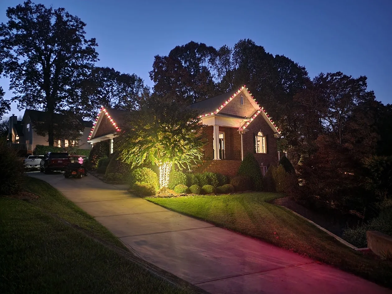 Candy-cane roofline and tree wrap lighting at a Mooresville home