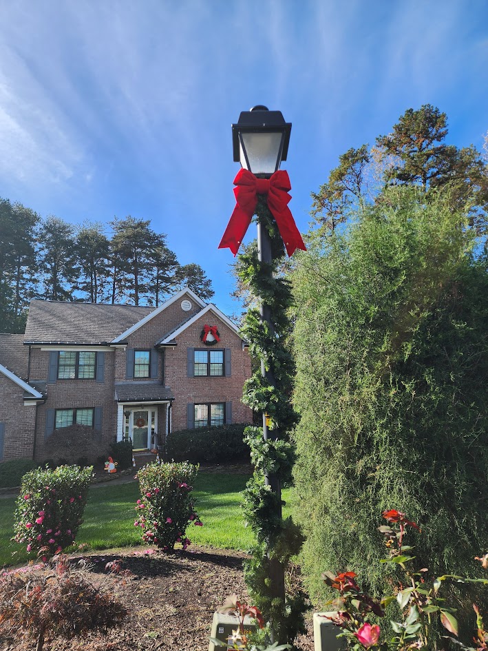 Garland and a red bow installed on a residential lamp post