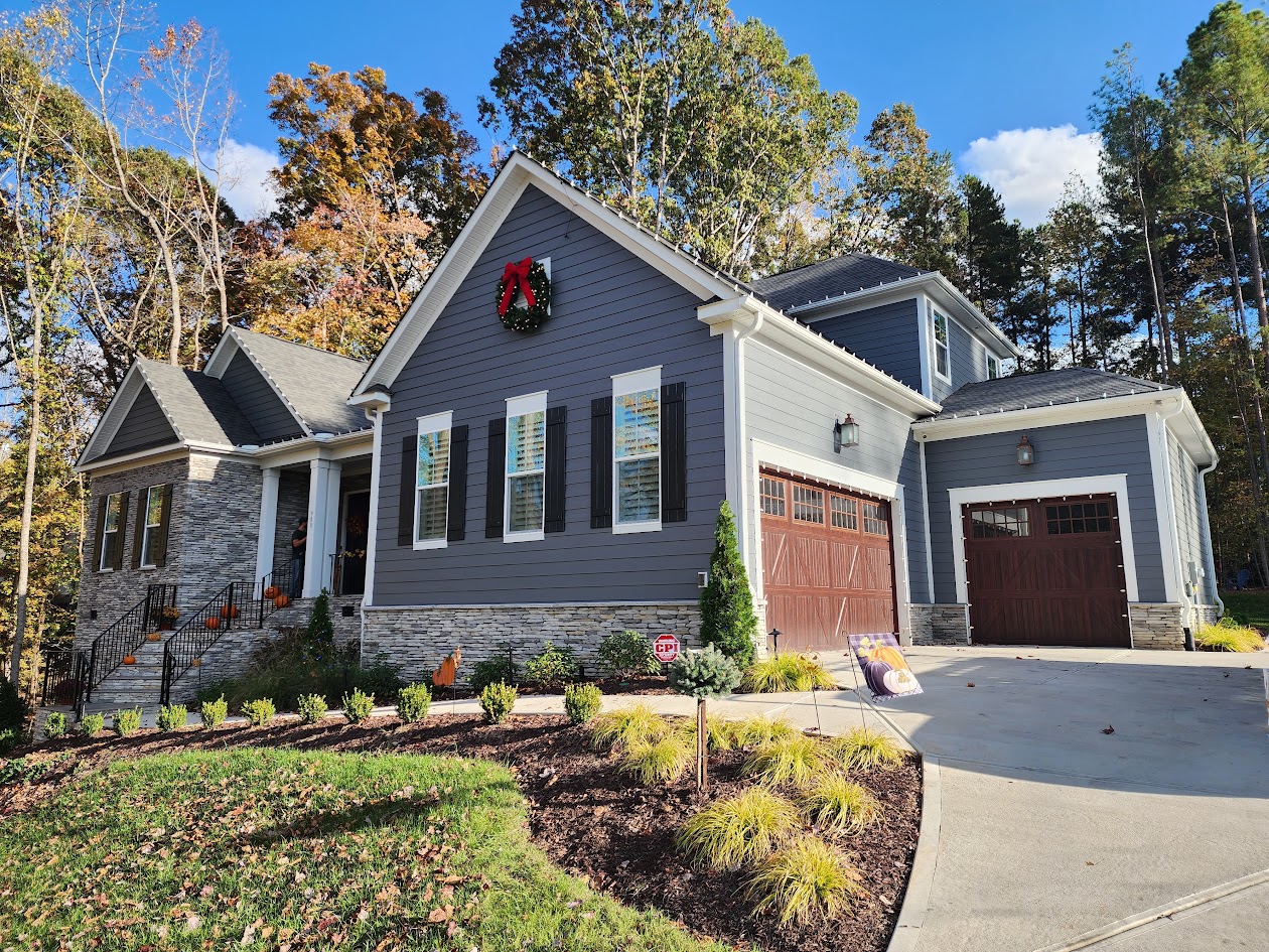Large wreath installed above the roofline of a blue home