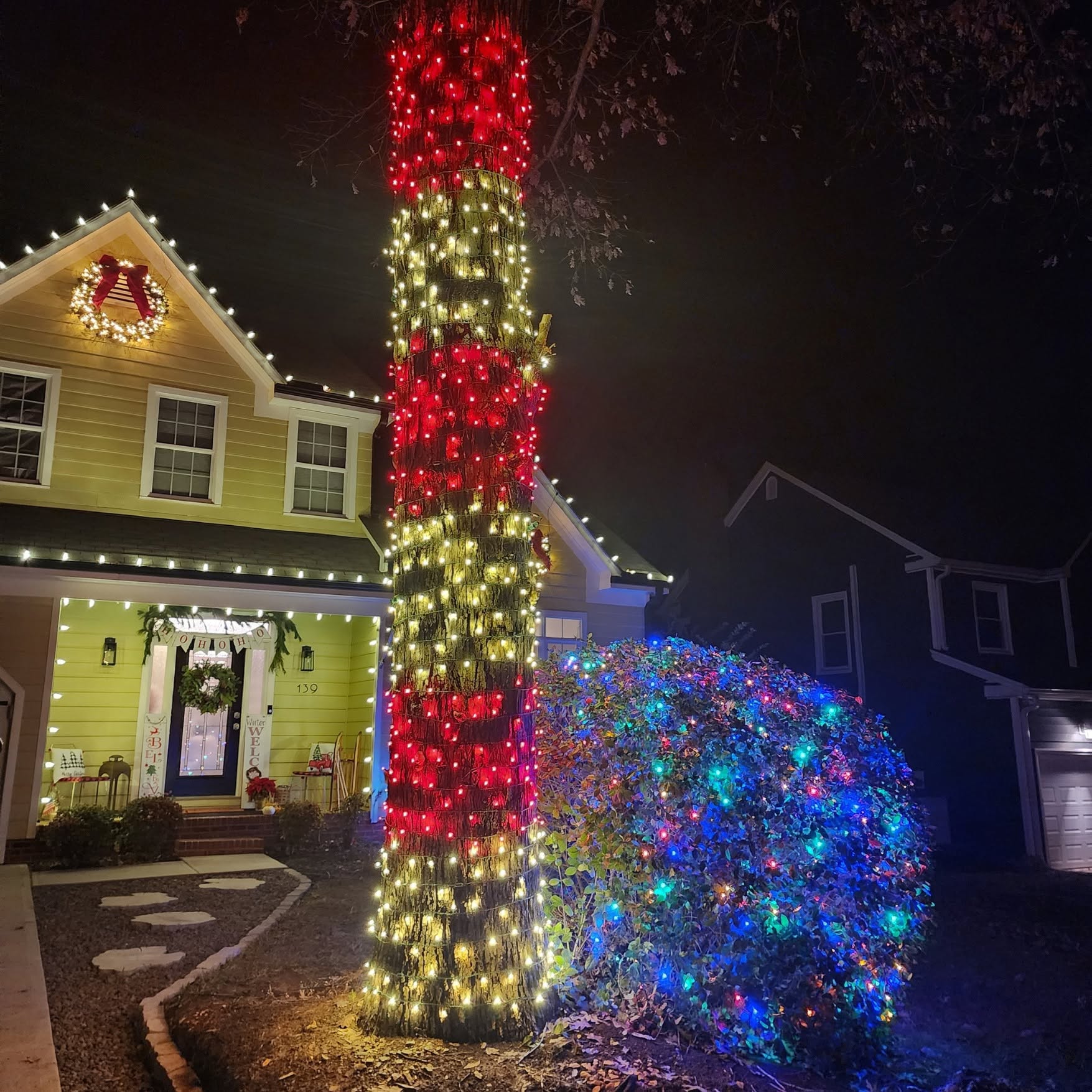 Red, warm white, and multicolor tree and landscape lighting on a Mooresville home