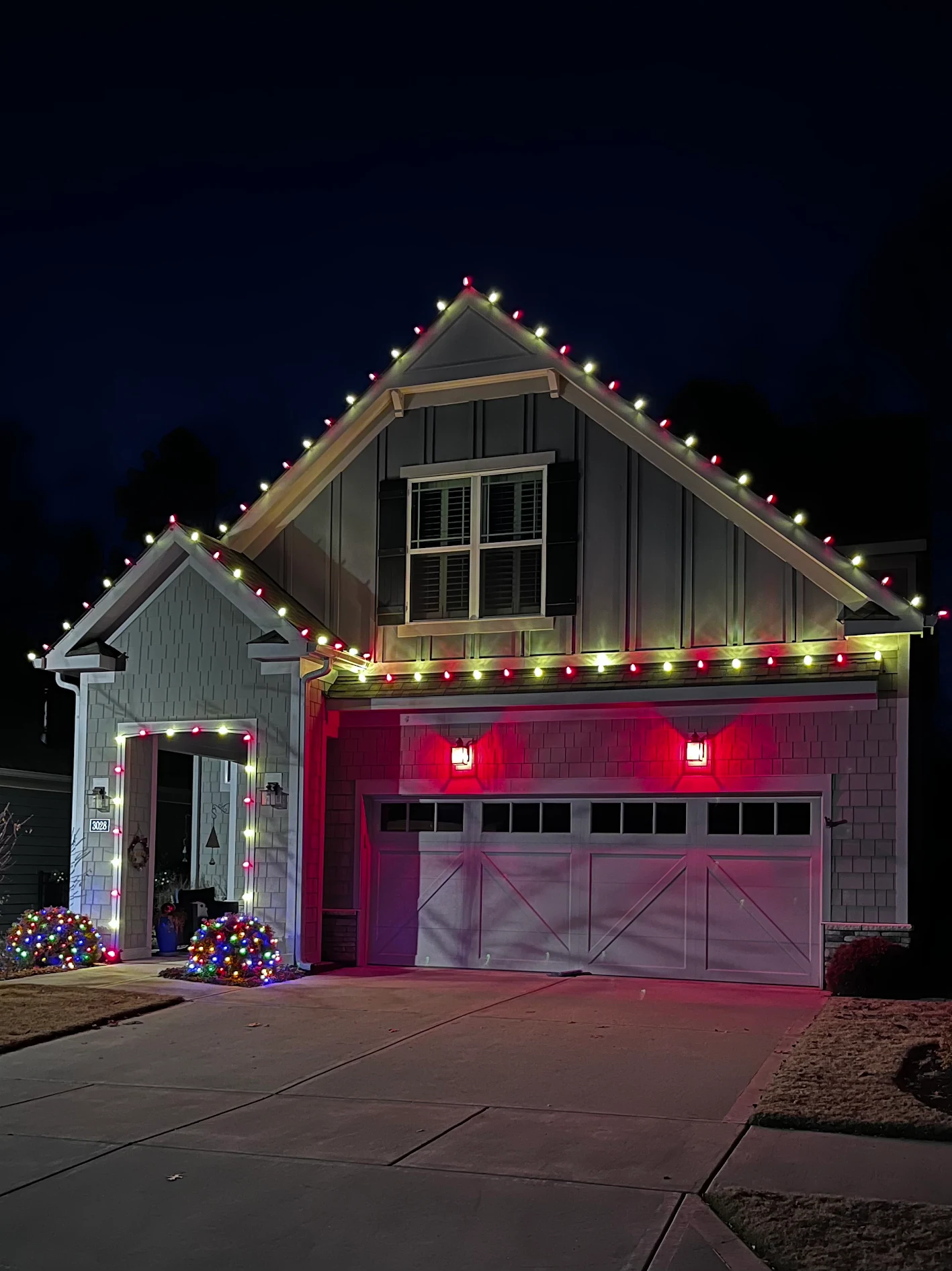 Red and warm white candy-cane roofline lighting on a home