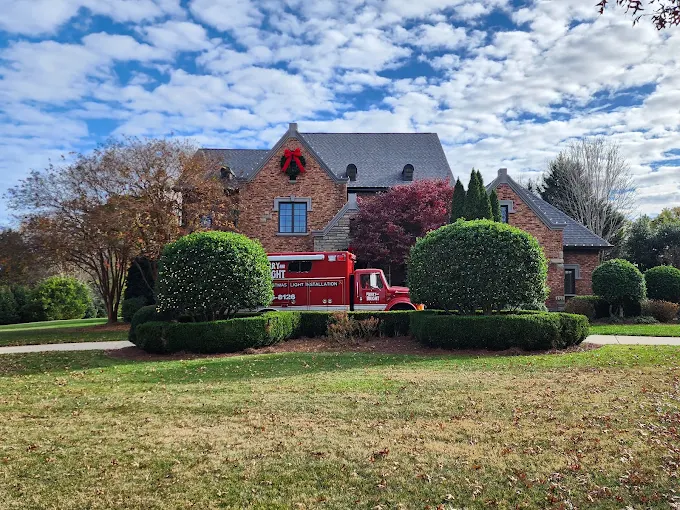 Merry & Bright truck parked at a home with a daytime wreath and roofline