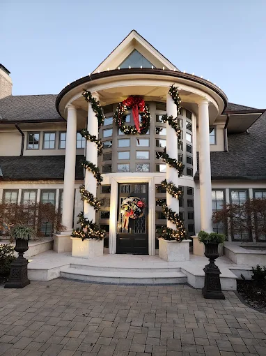 Garland, wreaths, and bows arranged around a curved home entry