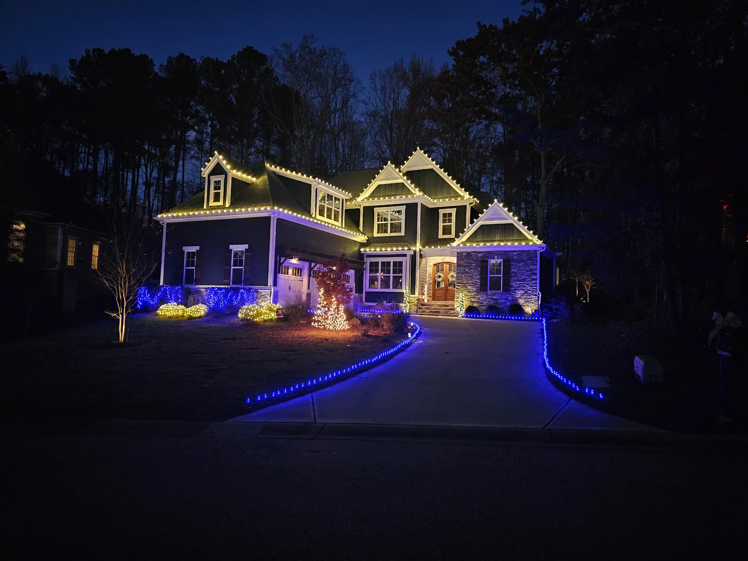Warm white roofline lighting with blue and warm white landscape accents
