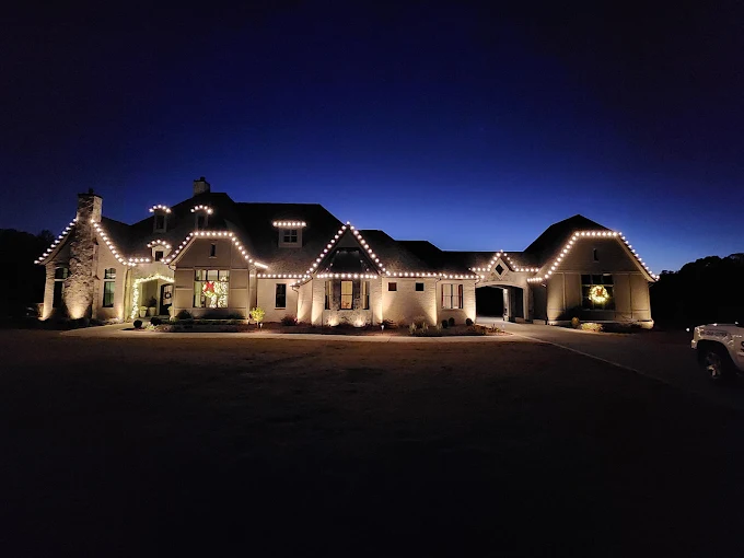 Warm-white roofline on a wide single-story home at dusk