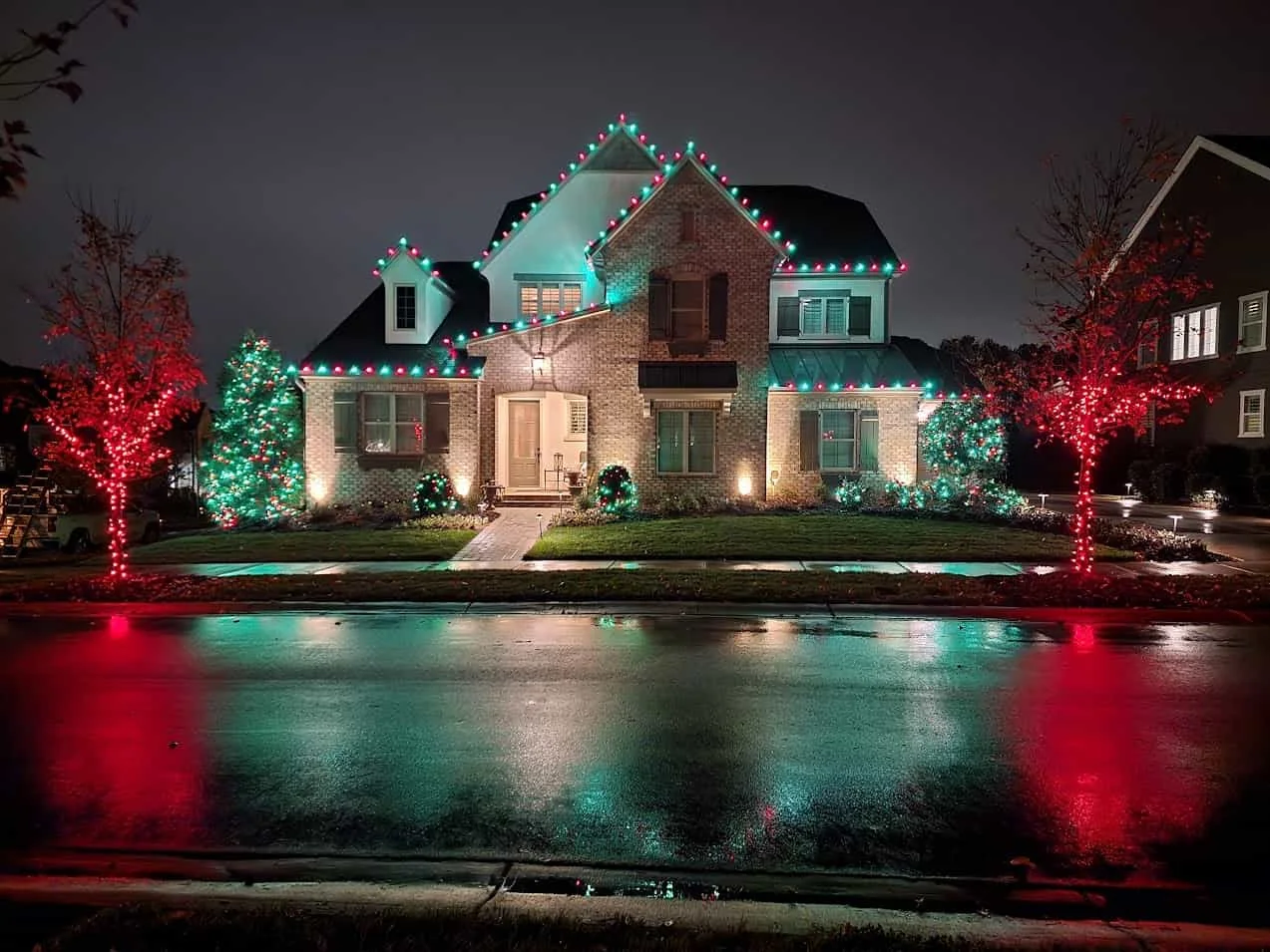 Red and green roofline, tree, and landscape lighting on a Waxhaw home