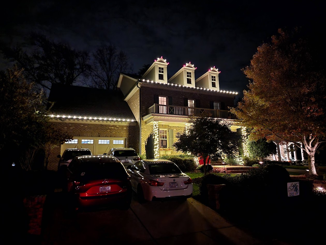 Warm-white roofline, dormers, and wrapped columns on a residence
