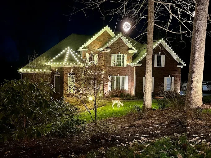 Warm-white lighting outlining a turret and roof ridges