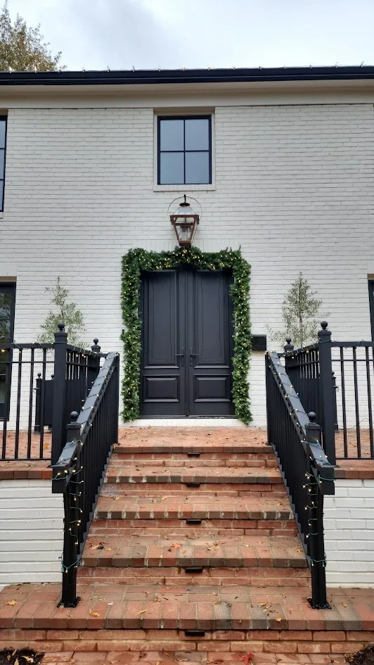 Garland framing the front door of a white residence